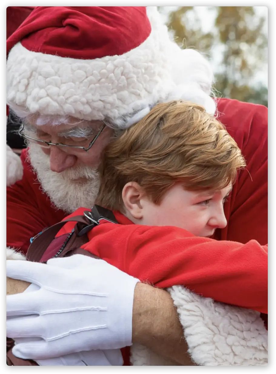 Photo of boy hugging Santa Claus.