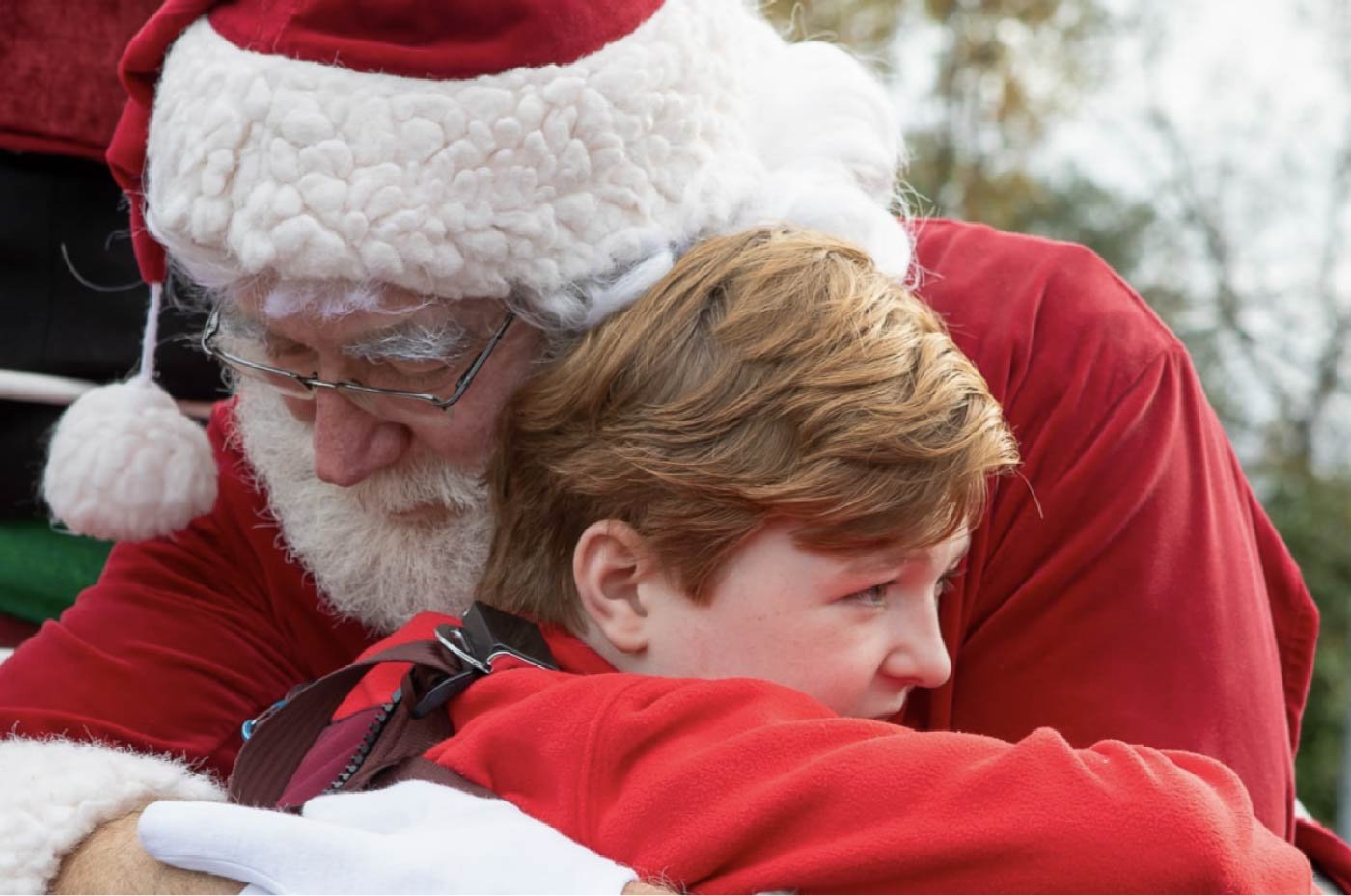 Photo of a boy hugging Santa Claus.
