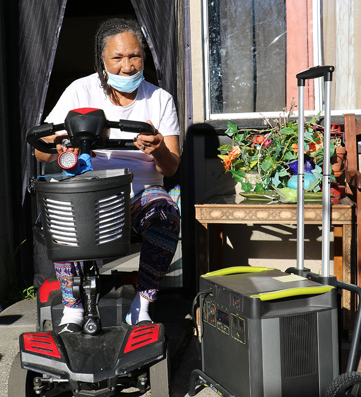 Photo of a woman in a scooter with a Yeti portable battery.